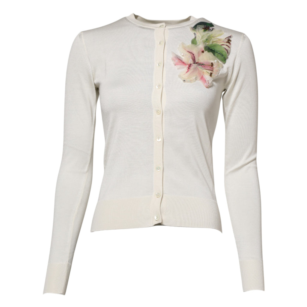 Cardigan en soie blanche Dolce & Gabbana avec boutons, détails floraux et coupe élégante, porté ou posé sur un fond neutre.