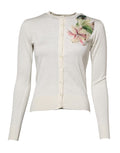 Cardigan en soie blanche Dolce & Gabbana avec broderies de lys et détails ornés, élégant pull pour femme.