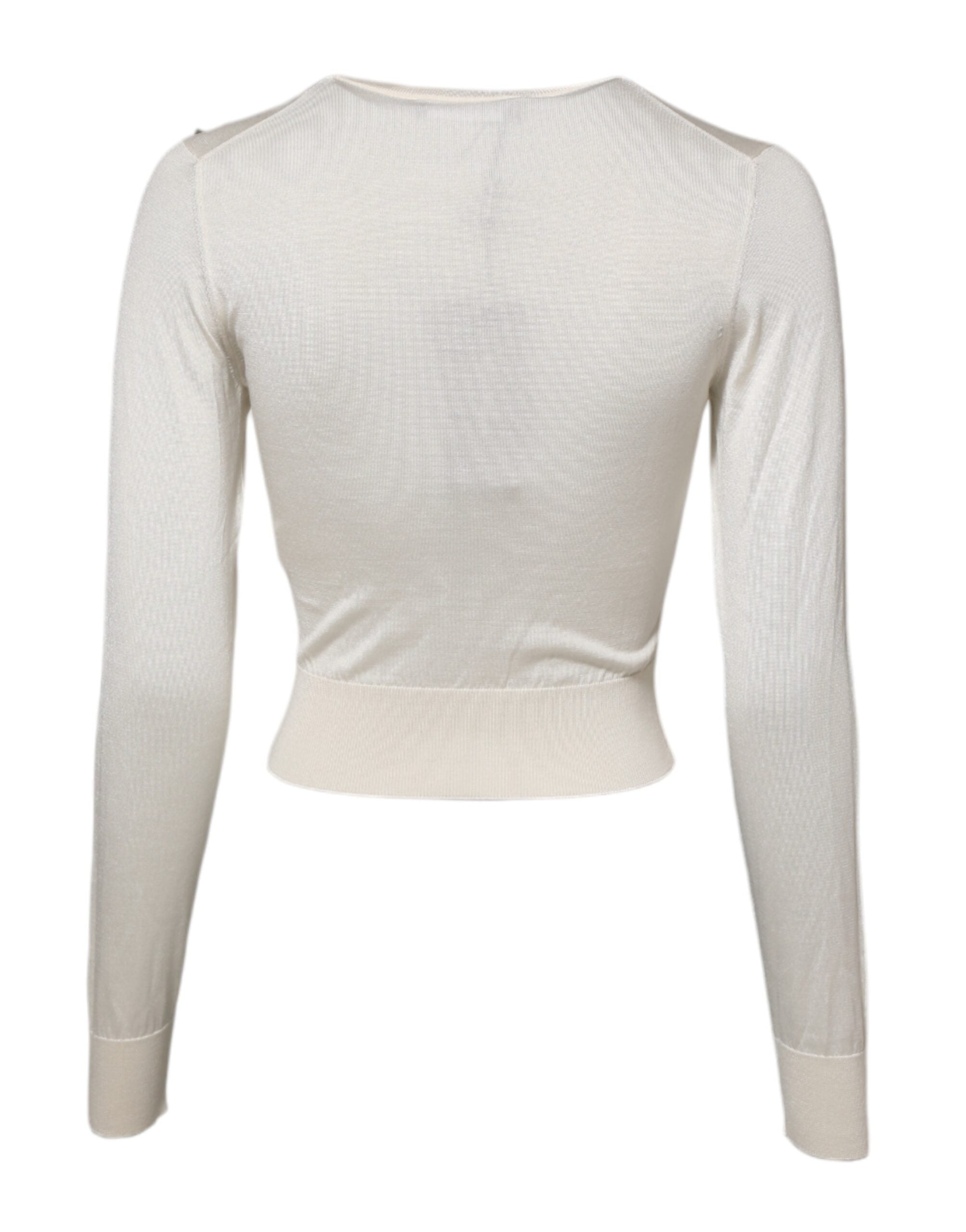 Pull en soie blanche Dolce & Gabbana avec embellissements de lys, doux et élégant, visible sur l'image.