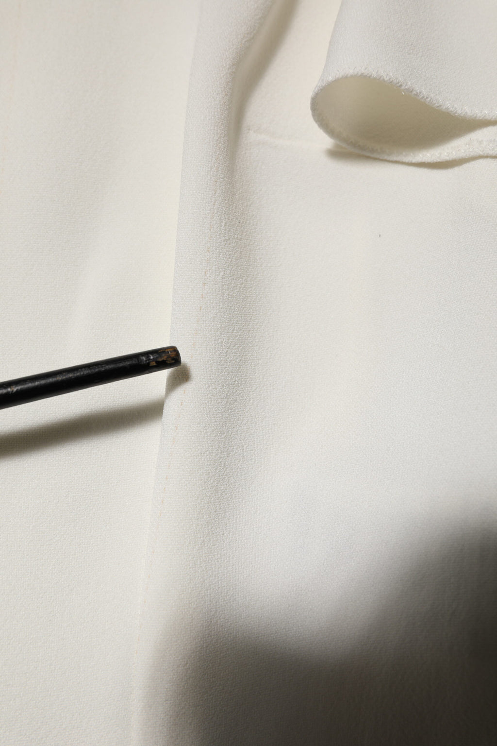 Chemise blanche Dolce & Gabbana à col rond et manches courtes, légère et élégante, visible en détail dans l’image.