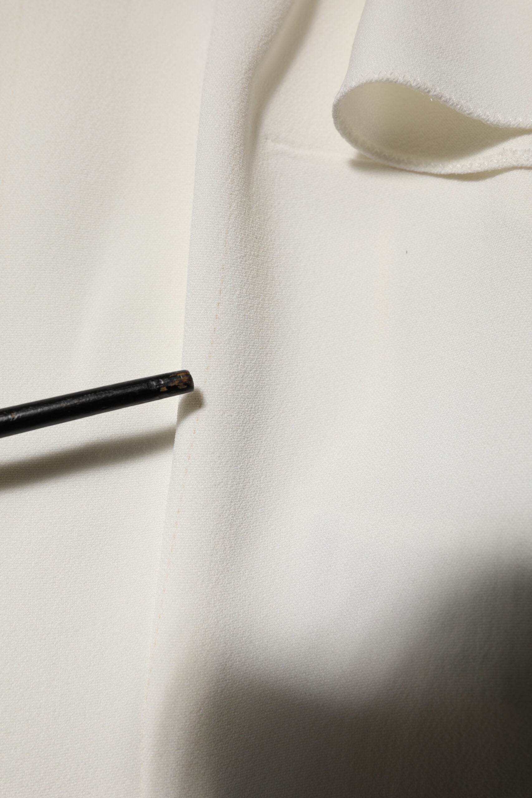Chemise blanche Dolce & Gabbana à col rond et manches courtes, légère et élégante, visible en détail dans l’image.