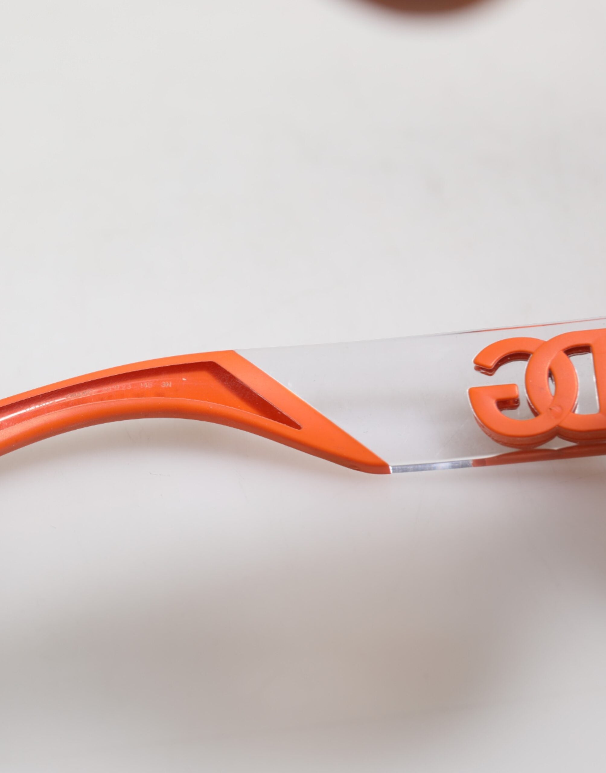 Lunettes de soleil Dolce & Gabbana Orange Reborn To Live avec monture ovale et logo, style élégant et moderne.
