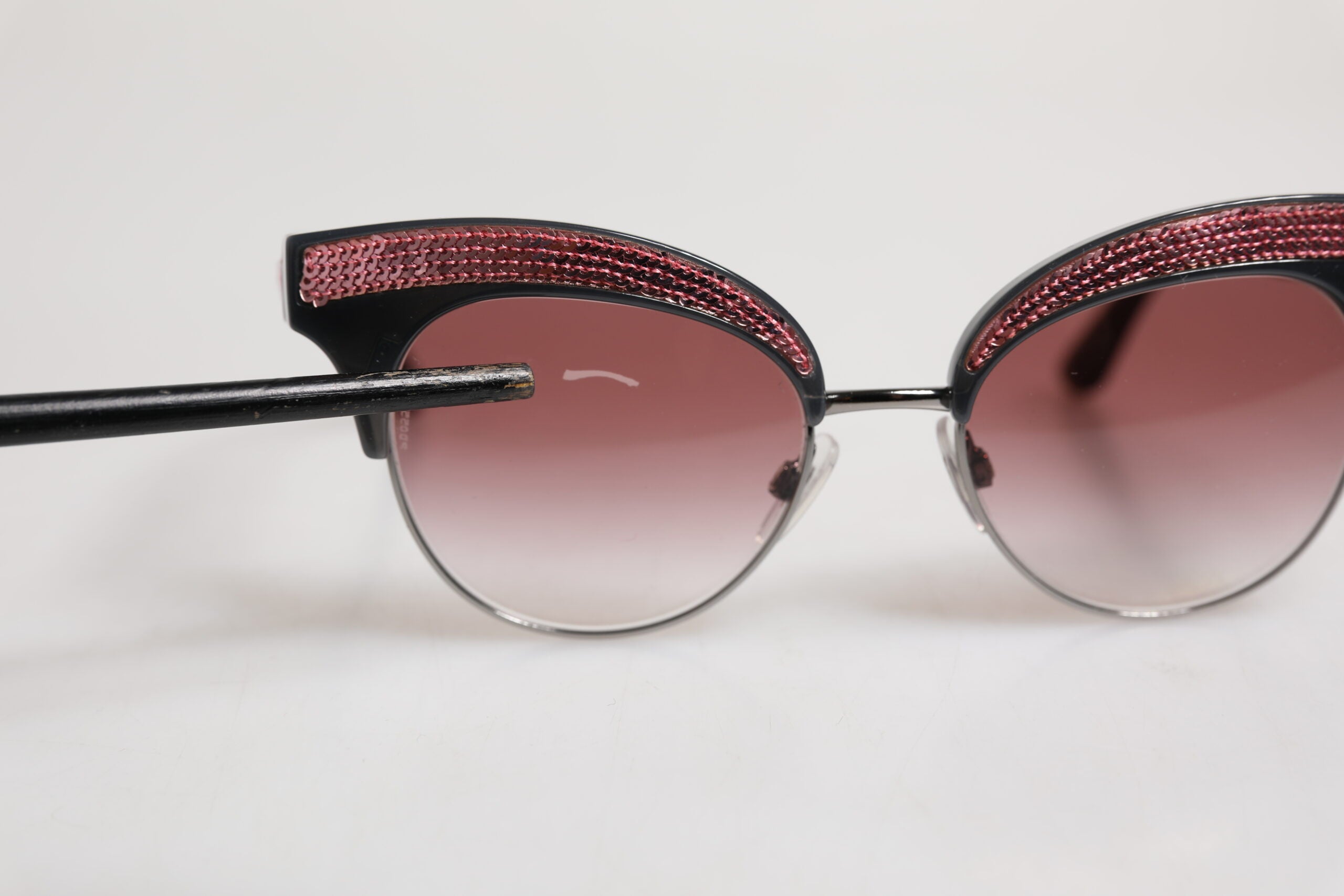 Lunettes de soleil Dolce & Gabbana noires et roses avec monture miroir en forme de chat œil et sequins.