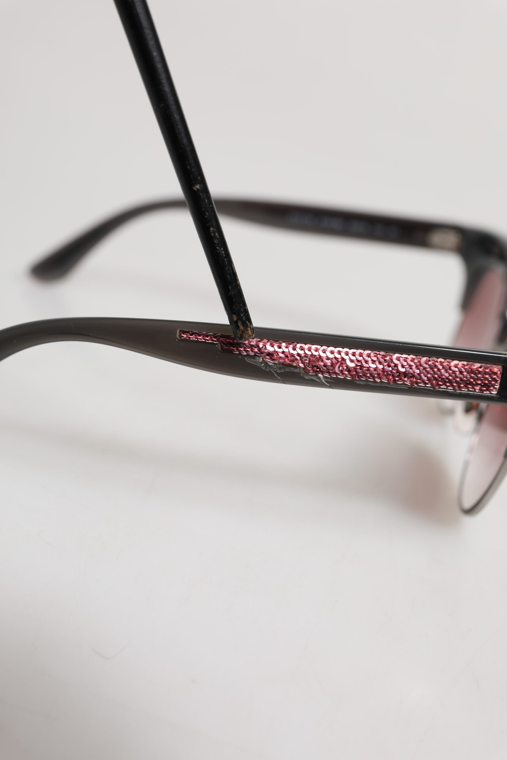 Lunettes de soleil Dolce & Gabbana noires et roses, monture miroir en forme de chat, avec sequins élégants.