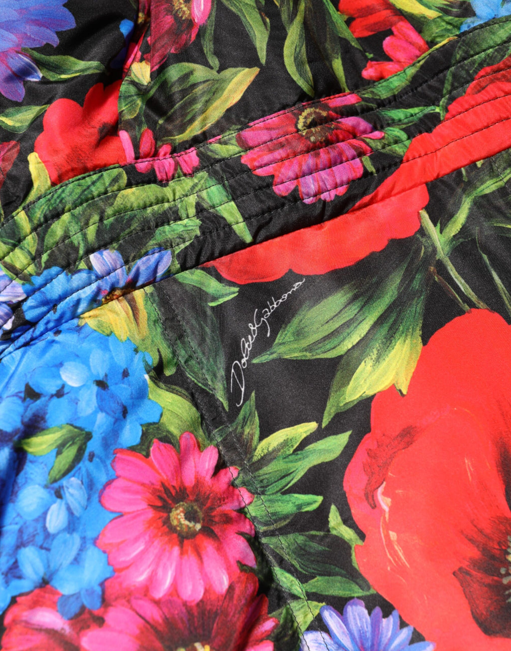 Manteau matelassé Dolce & Gabbana avec capuche, motifs floraux multicolores, chaud et tendance pour l'hiver.