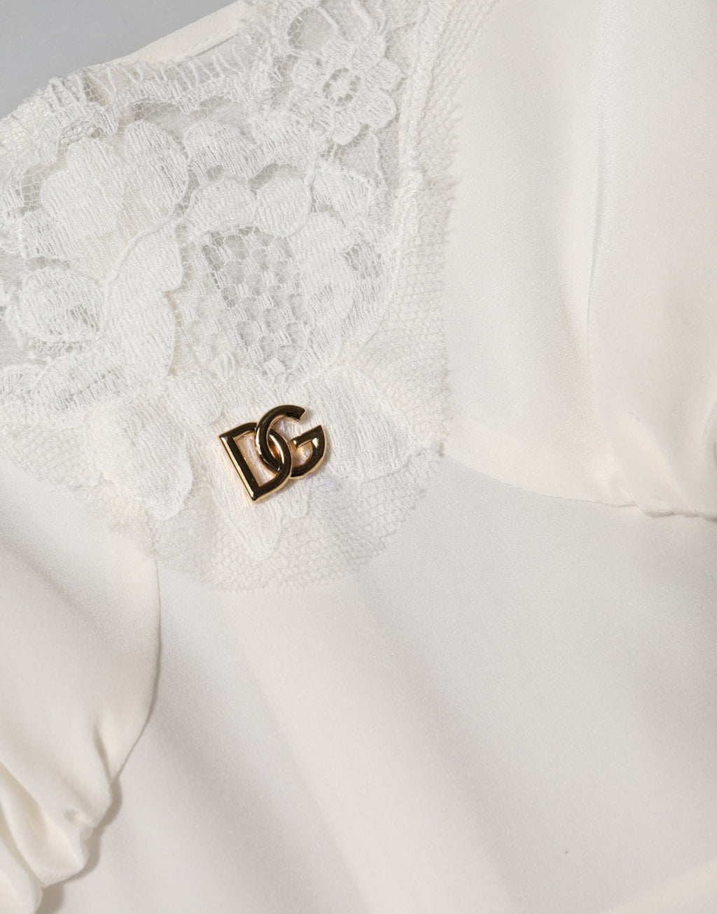 Robe de nuit en soie blanche Dolce & Gabbana avec dentelle, logo doré DG, élégante et raffinée.