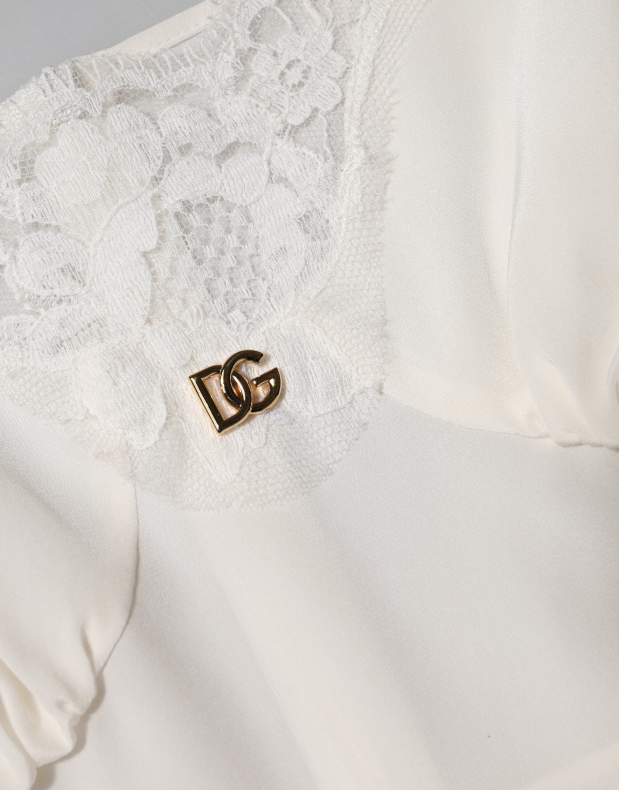 Robe de nuit en soie blanche Dolce & Gabbana avec dentelle, logo doré DG, élégante et raffinée.