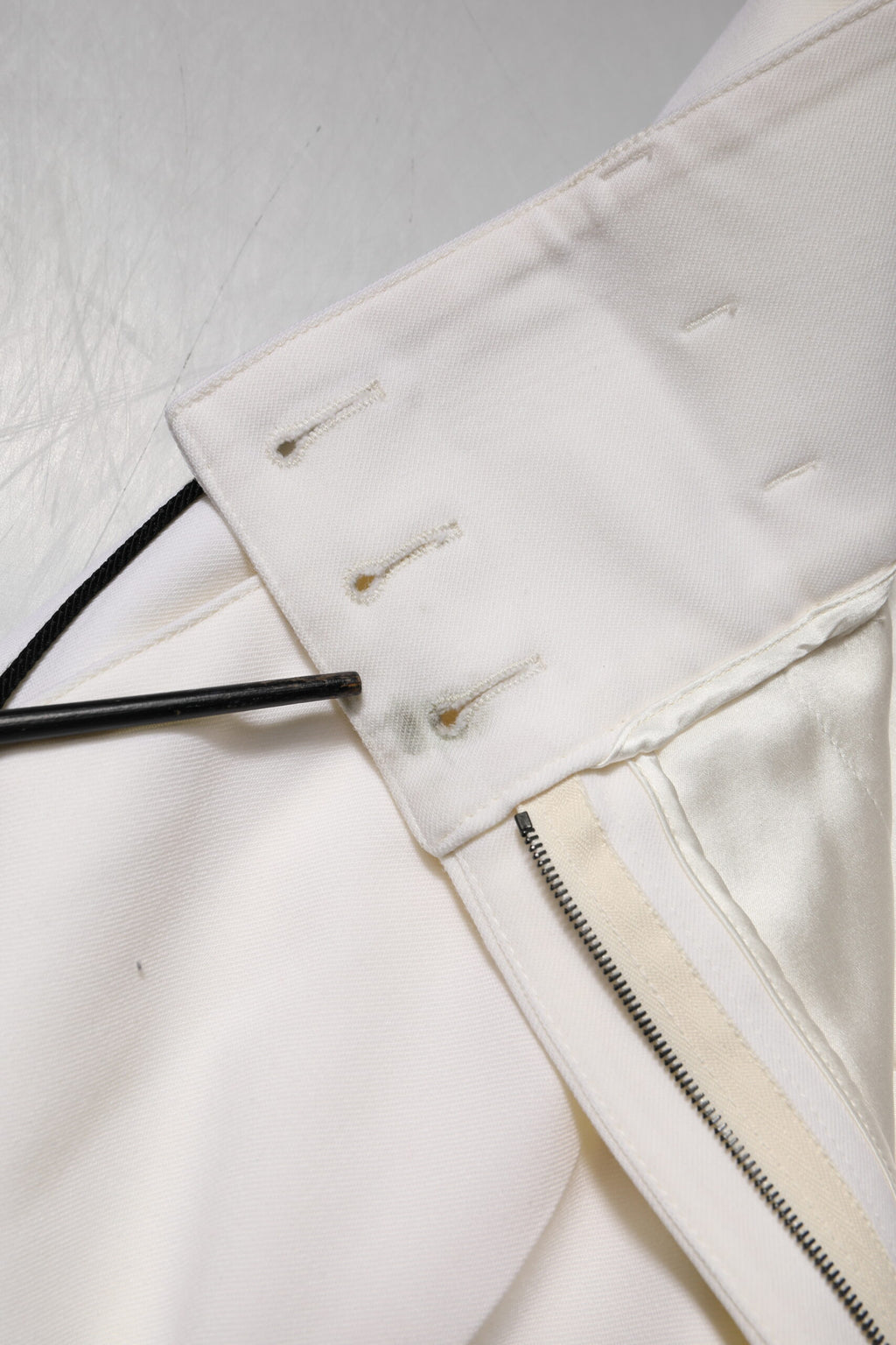 Pantalons en laine blanche à taille haute et coupe tapered de Dolce & Gabbana, visibles sur l'image.