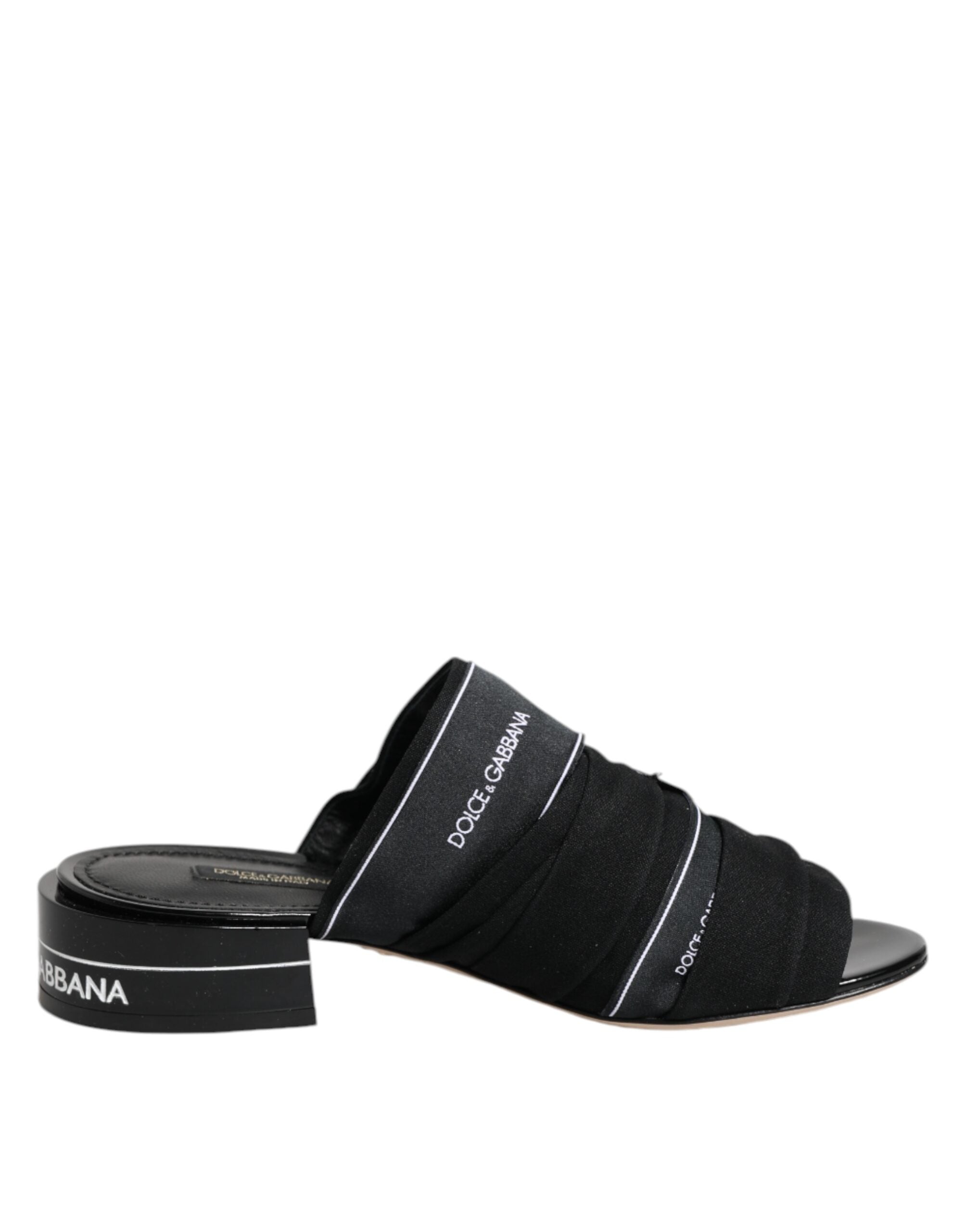 Sandales Dolce & Gabbana noires à enfiler, semelle plate et design élégant visibles sur l'image.