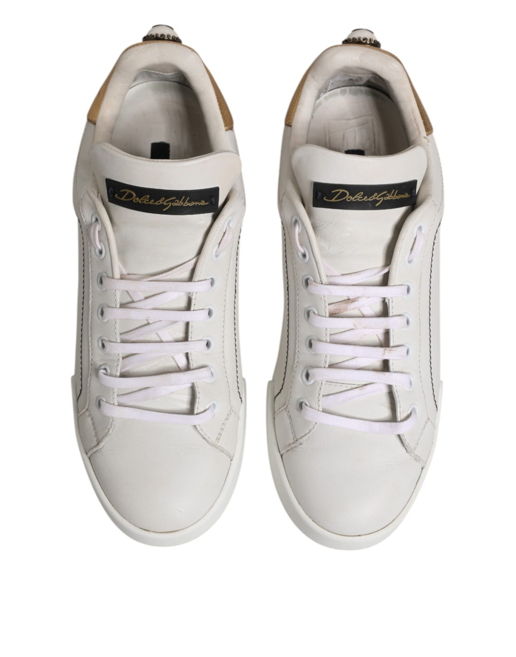 Chaussures sneakers basses en cuir blanc et or Dolce & Gabbana, élégantes et modernes, visibles en gros plan.