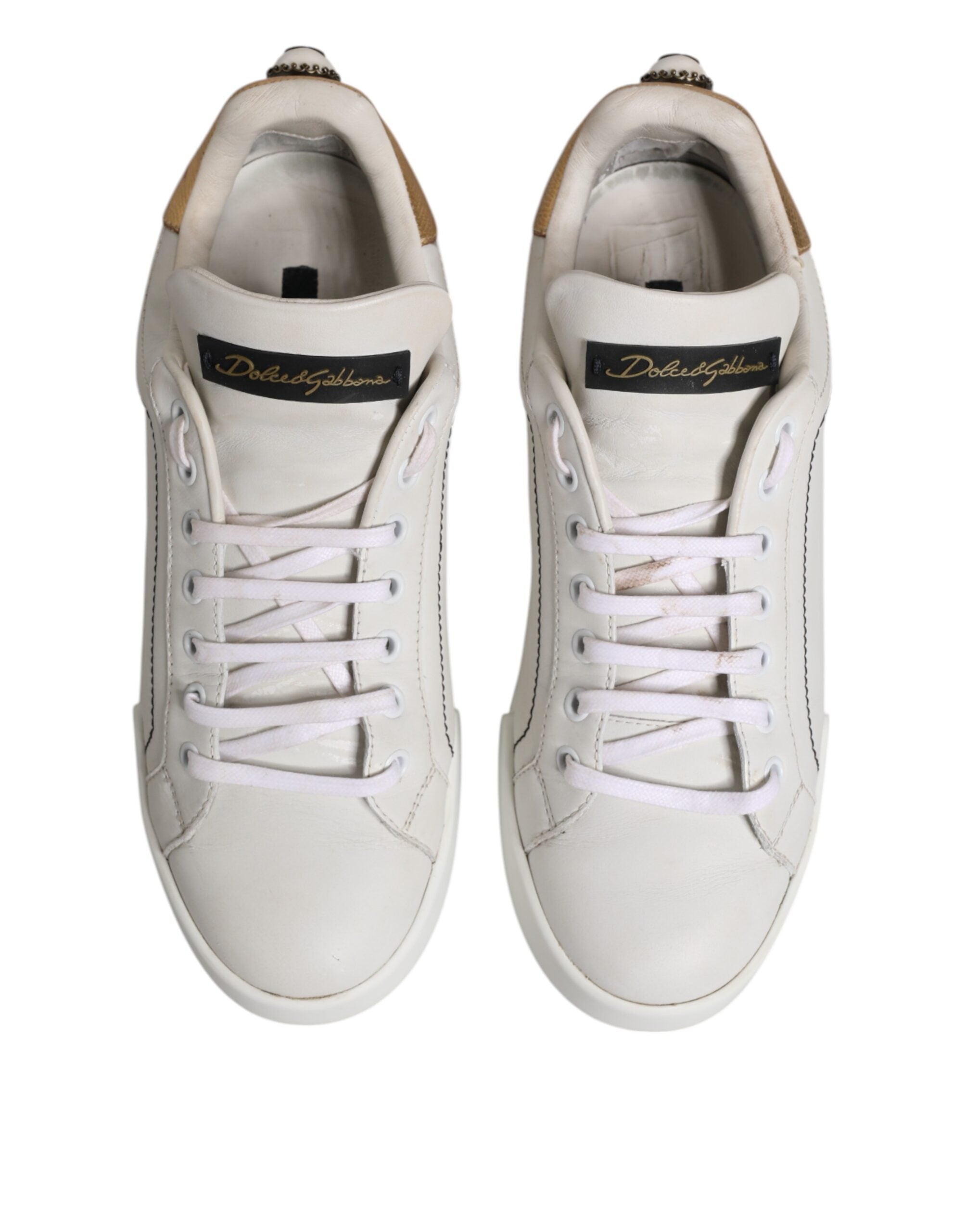 Chaussures sneakers basses en cuir blanc et or Dolce & Gabbana, élégantes et modernes, visibles en gros plan.