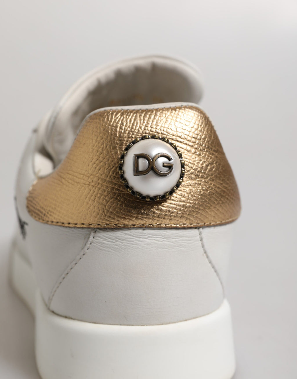 Chaussures sneakers basses en cuir blanc et or Dolce & Gabbana, style élégant et moderne, vue de face.