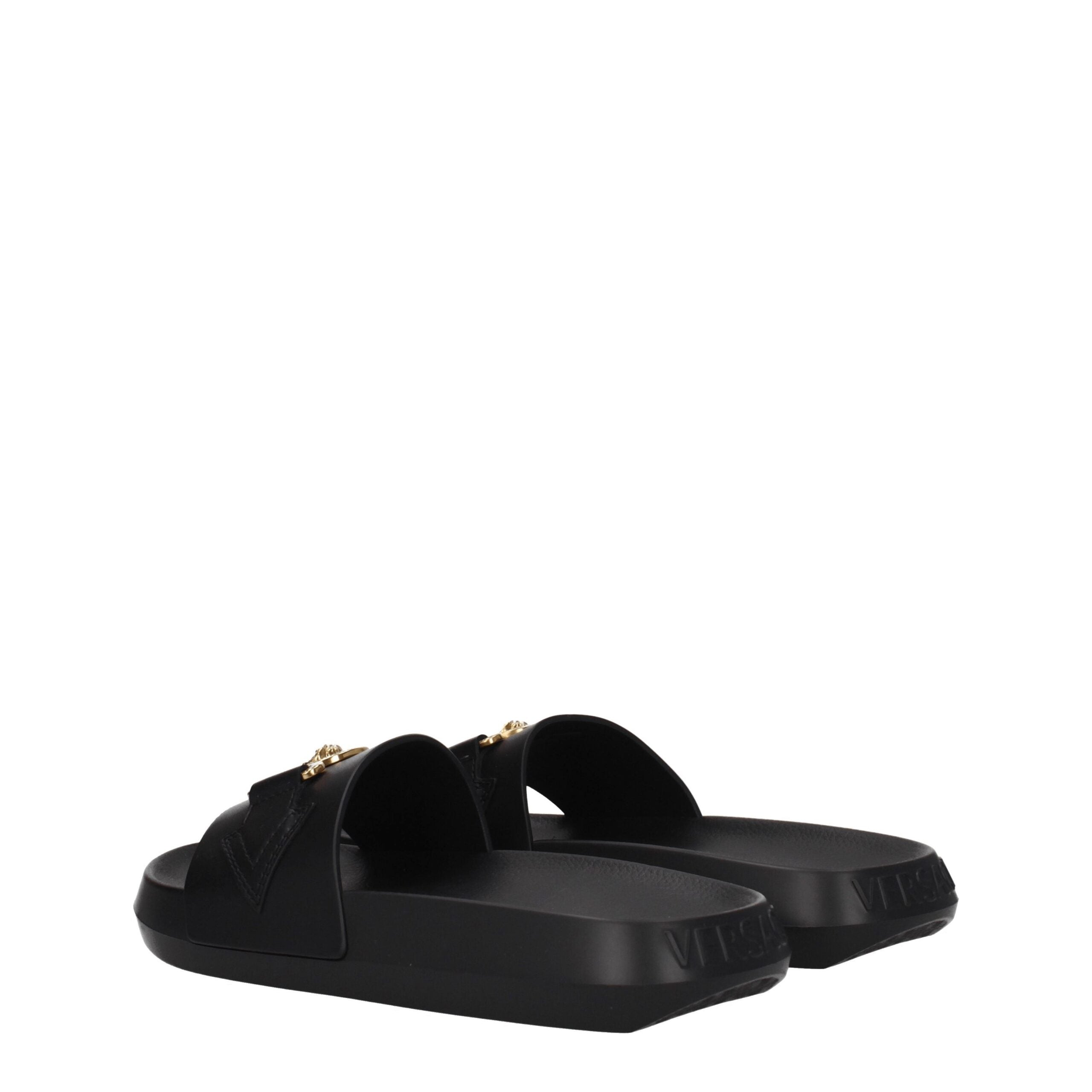 Chaussons en cuir noir de marque Versace, style élégant et confortable, avec logo distinctif visible sur la chaussure.