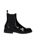 Bottes en cuir noir Dolce & Gabbana pour la cheville, élégantes et sophistiquées, visibles dans l'image.