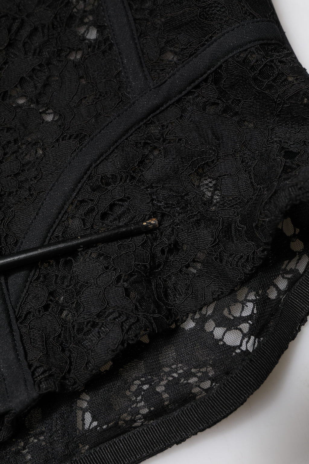 Bustier court noir en dentelle florale sans bretelles de Dolce & Gabbana, détail élégant et féminin visible sur l'image.