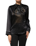 Chemisier Dolce & Gabbana en soie noire avec col ascot et boutons, vue de face.