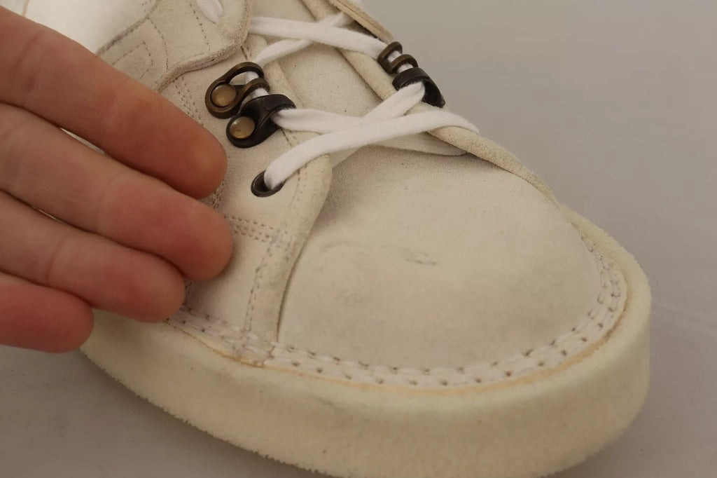 Bottes pour hommes en cuir blanc Dolce & Gabbana avec lacets, élégantes et modernes, visibles en gros plan.