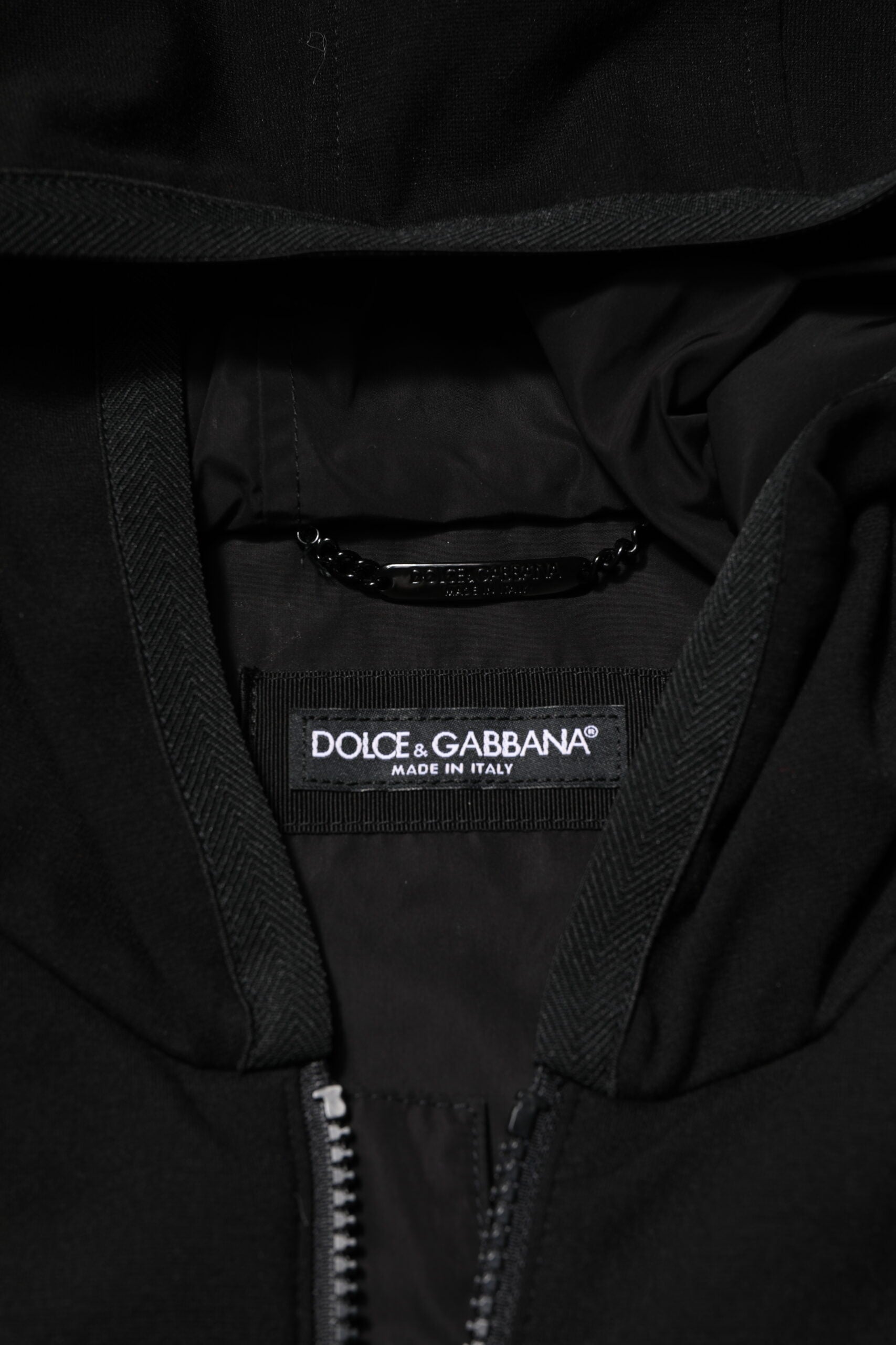 Veste sans manches Dolce & Gabbana noire avec capuche, logo et plaque sur le devant, en tissu élégant et moderne.