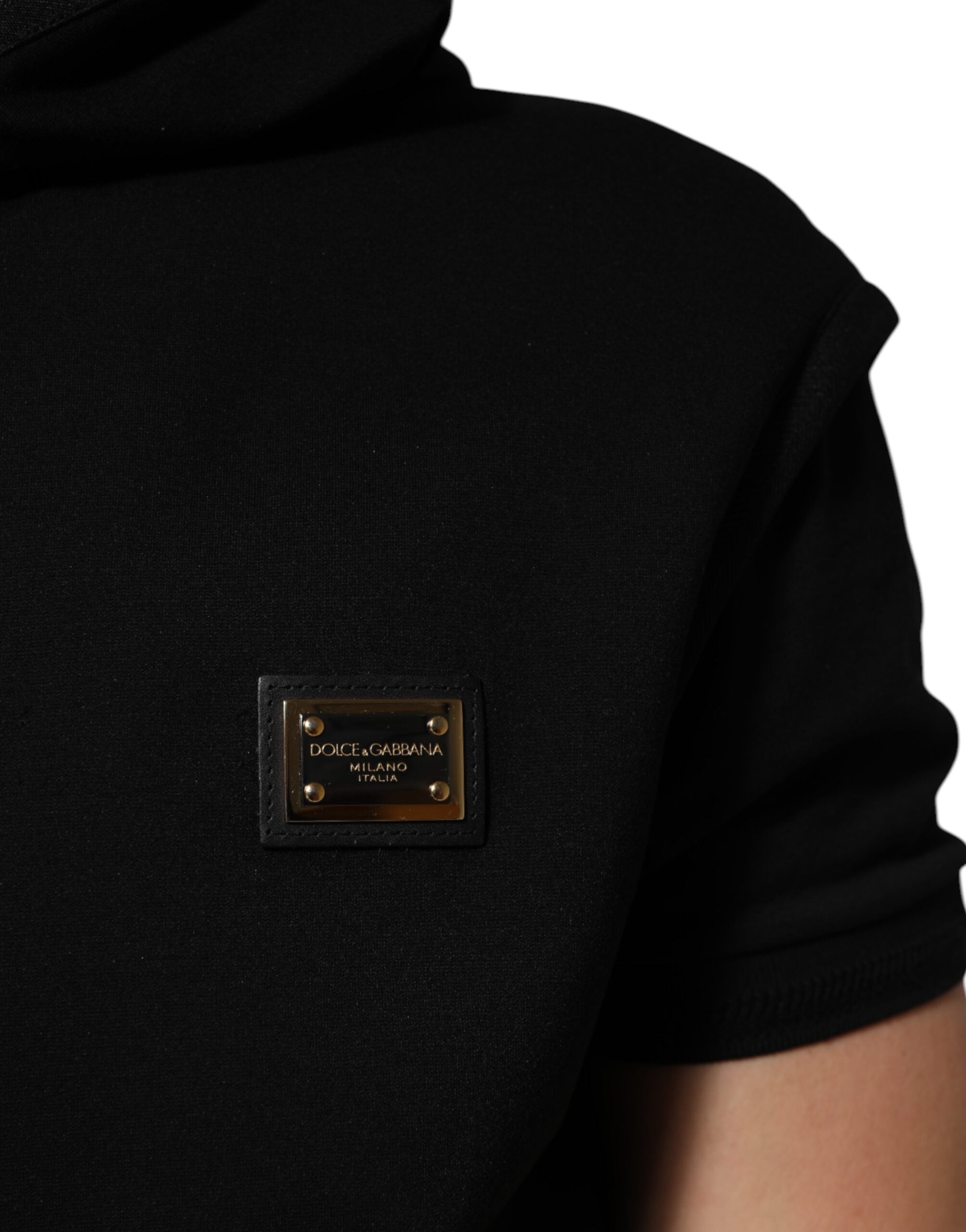 Veste sans manches noire Dolce & Gabbana avec capuche, logo et plaque en relief, style moderne et élégant.