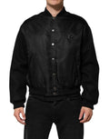 Veste bomber noire en polyester Dolce & Gabbana avec plaque logo, détails élégants et design contemporain visible sur l'image.