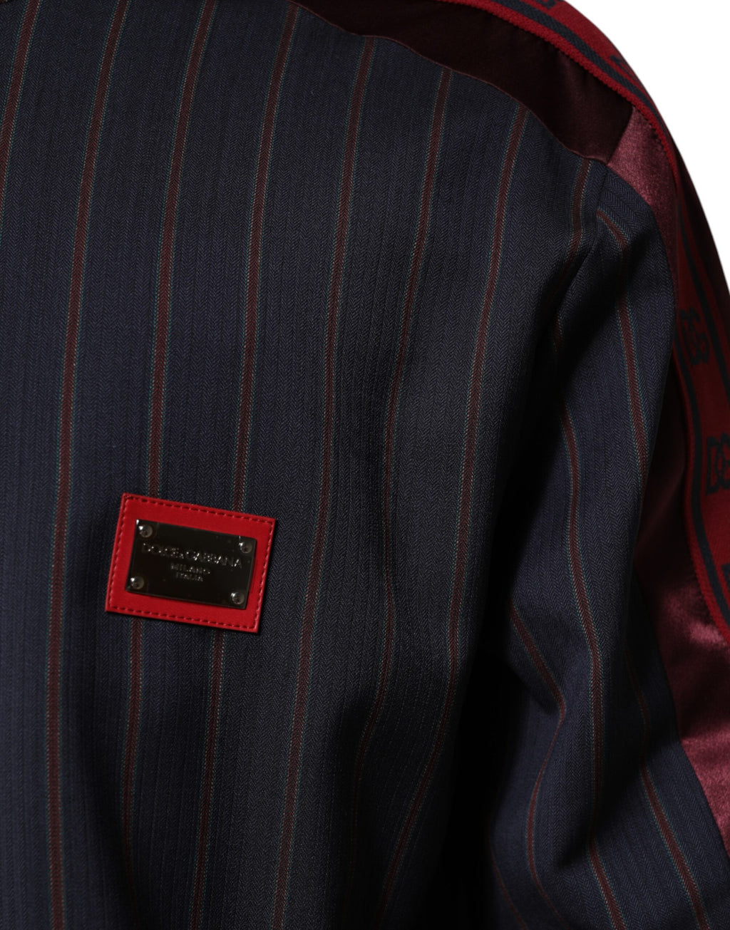 Veste Dolce & Gabbana à zip complet avec logo, rayures bleues et rouges, plaque logo sur la poitrine, style décontracté.
