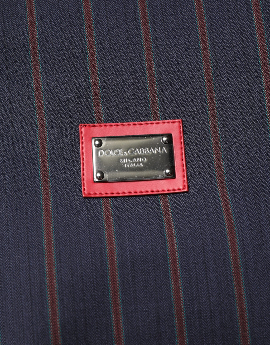 Veste zippée Dolce & Gabbana avec rayures bleues et rouges, logo en plaque sur la poitrine, style chic et décontracté.