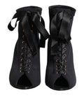 Chaussures Dolce & Gabbana : bottines noires à talons stilettos avec lacets, en cuir élégant.