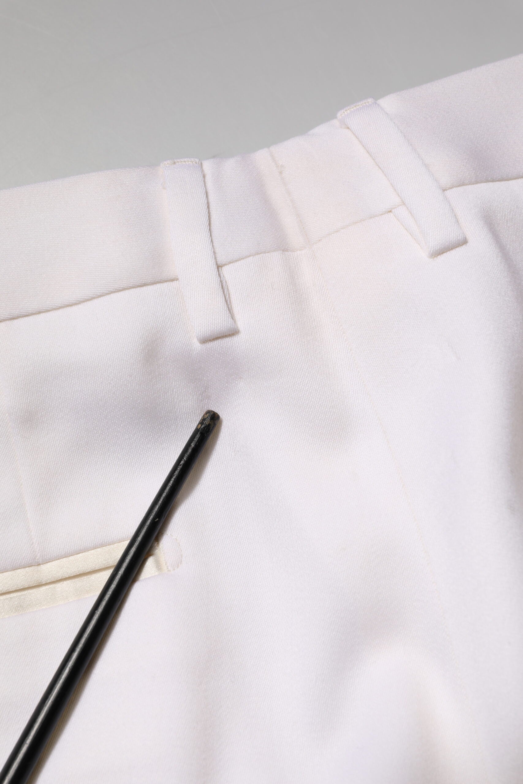 Pantalon formel blanc en polyester Dolce & Gabbana, coupe tapered, vue de face sur un fond neutre.