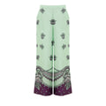 Pantalons décontractés en soie verte de Gucci, coupe confortable et élégante, visibles en détail sur l'image.