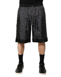 Shorts bermuda en soie gris et noir Dolce & Gabbana avec logo DG pour homme, visibles avec détails du tissu et design élégant.