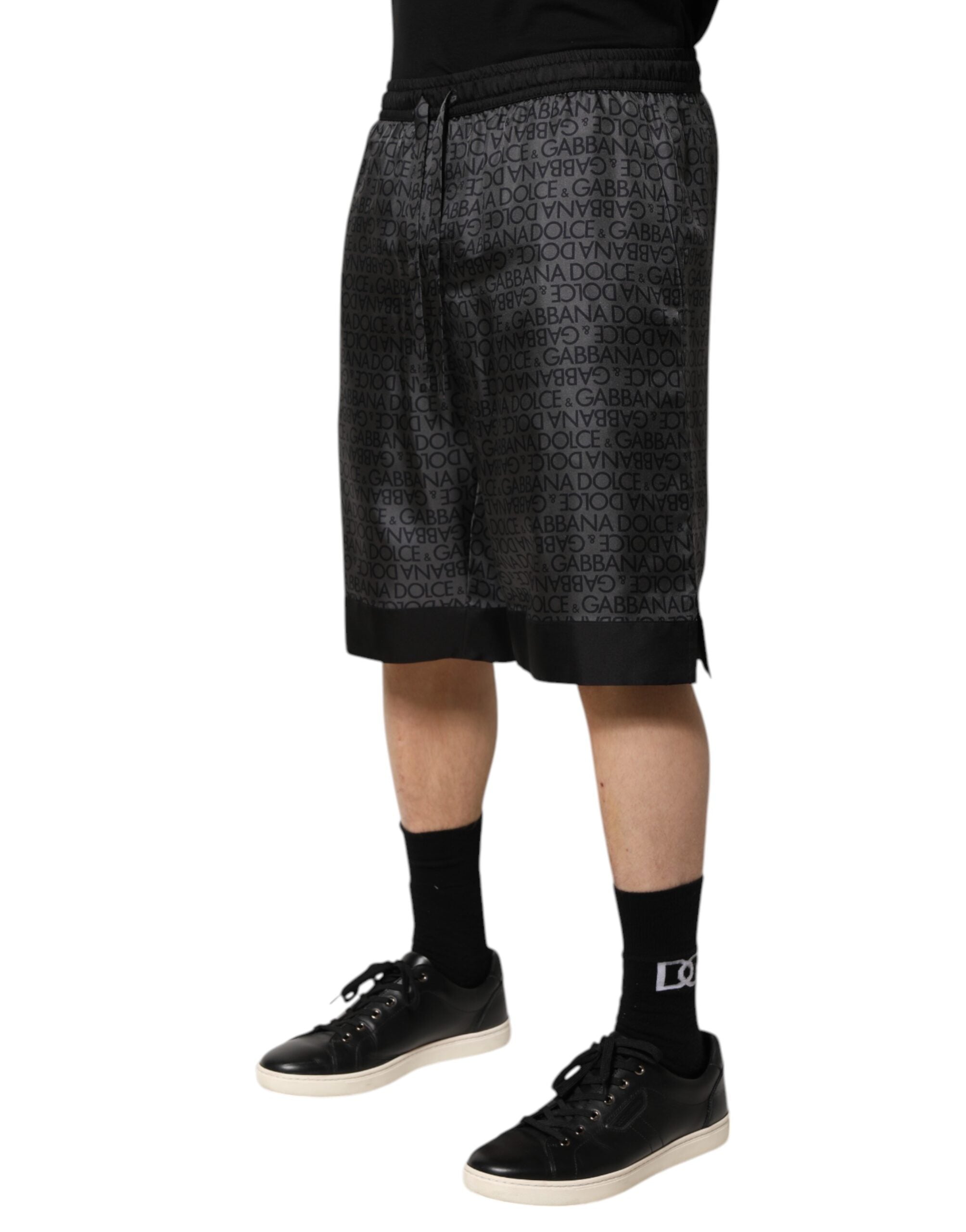 Shorts bermuda pour homme en soie gris et noir Dolce & Gabbana avec logo DG visible, style élégant et confortable.