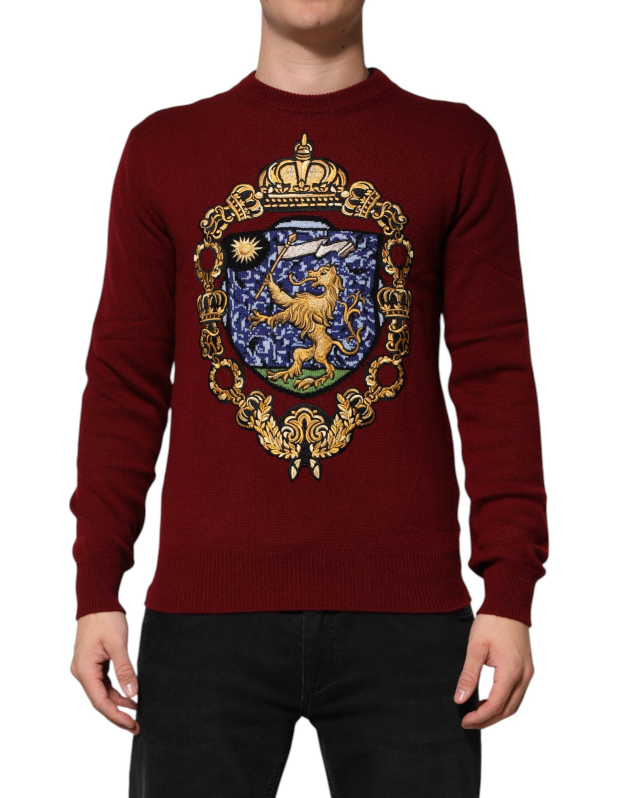Pull Dolce & Gabbana en cachemire bordeaux avec un lion et un écusson, doux et élégant, porté sur un mannequin.