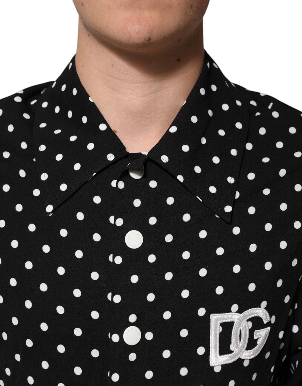 T-shirt polo noir à pois blancs avec manches courtes et col classique par Dolce & Gabbana, vue de face.