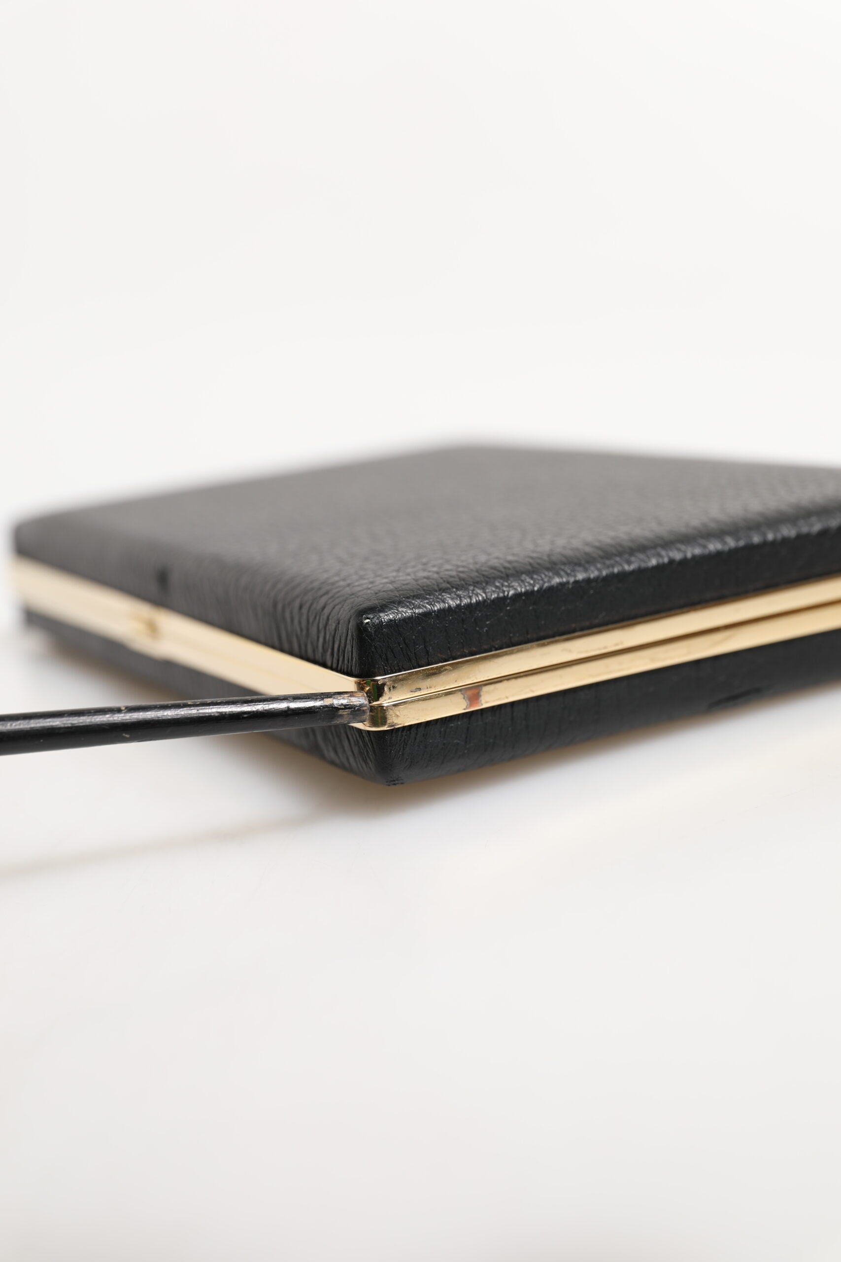 Pochette en cuir noir Dolce & Gabbana avec cadre doré, idéale pour soirée et événements élégants.