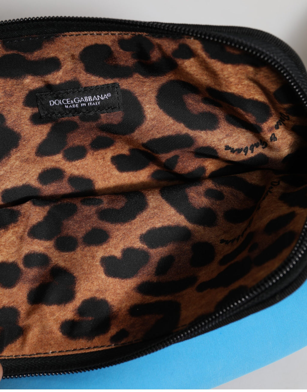 Pochette en nylon bleu Dolce & Gabbana avec logo DG imprimé, fermeture éclair et design élégant.