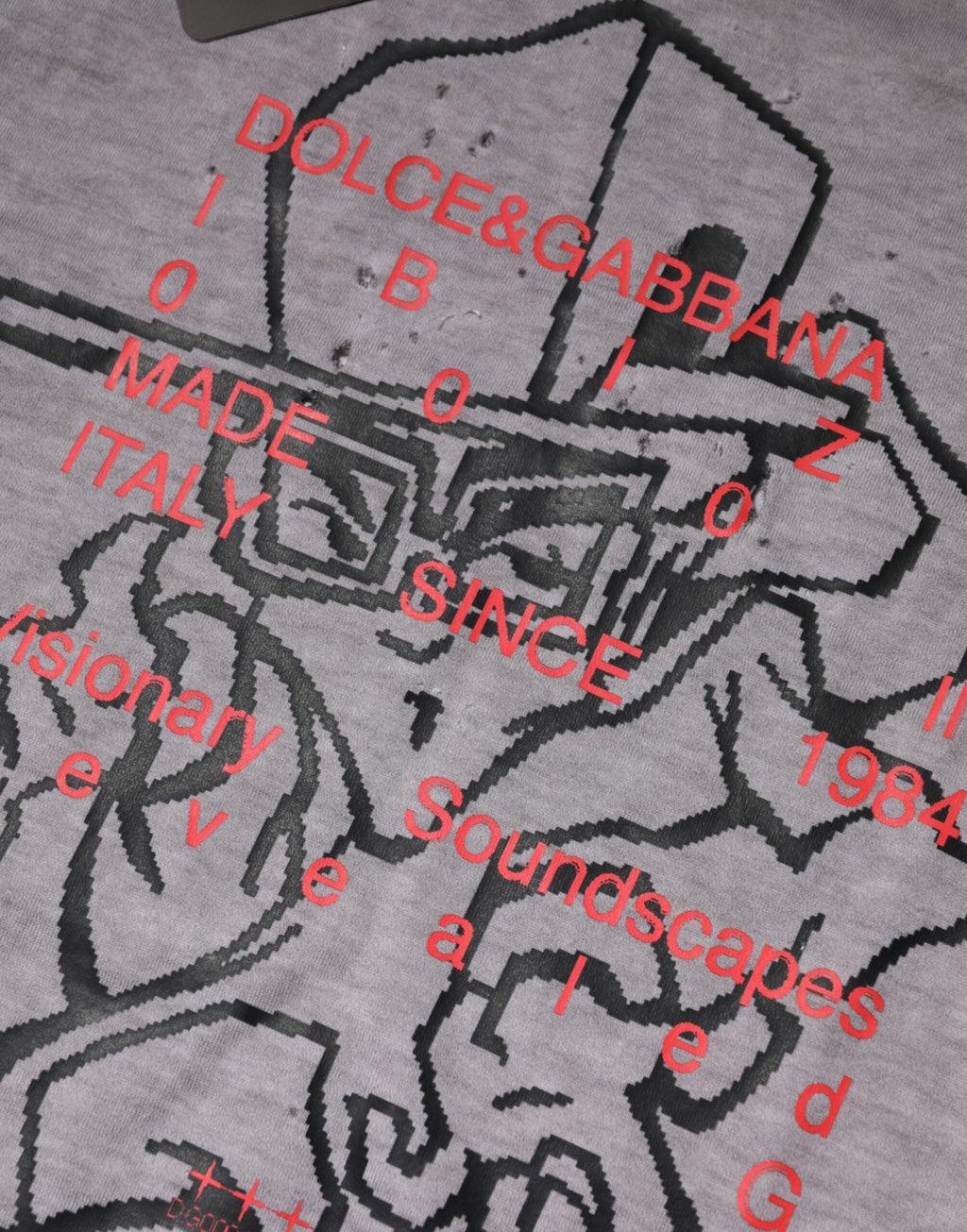 T-shirt homme gris à col rond Dolce & Gabbana avec motif graphique en coton, style moderne et élégant.