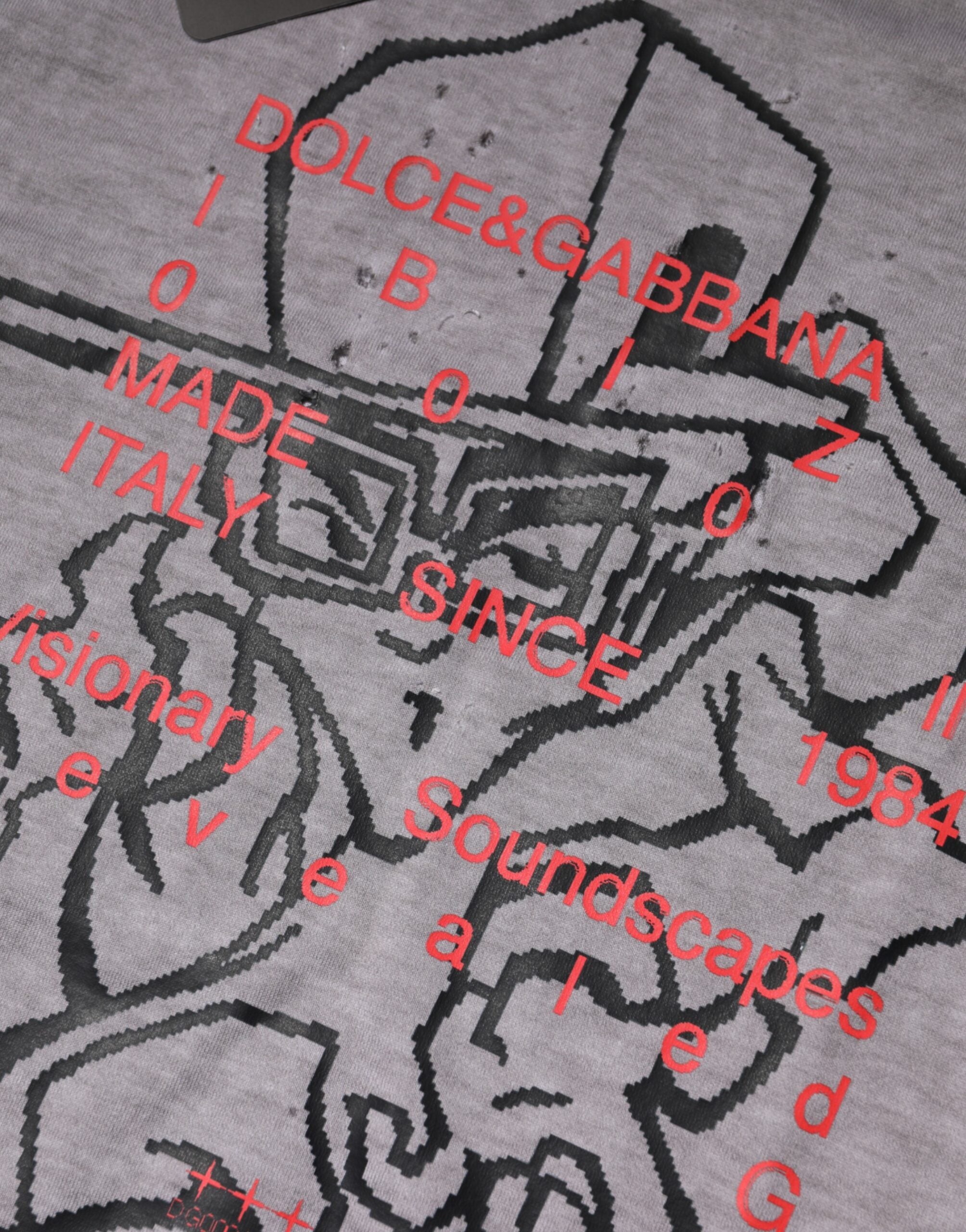T-shirt homme gris à col rond Dolce & Gabbana avec motif graphique en coton, style moderne et élégant.