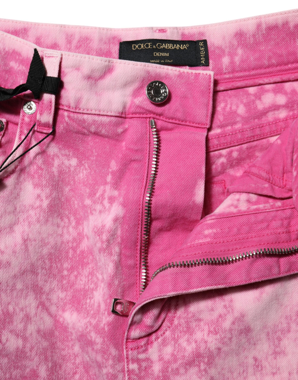 Jeans en denim rose à la mode tie-dye, taille haute, coupe tapered, de la marque Dolce & Gabbana, visibles sur l'image.