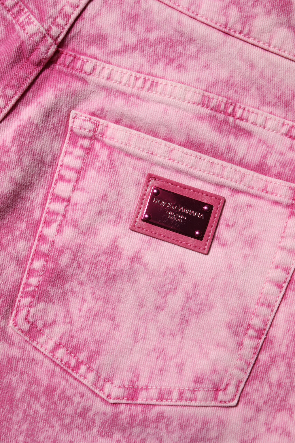 Jeans en denim rose tie-dye Dolce & Gabbana à taille haute et coupe tapered, mode tendance et élégante.