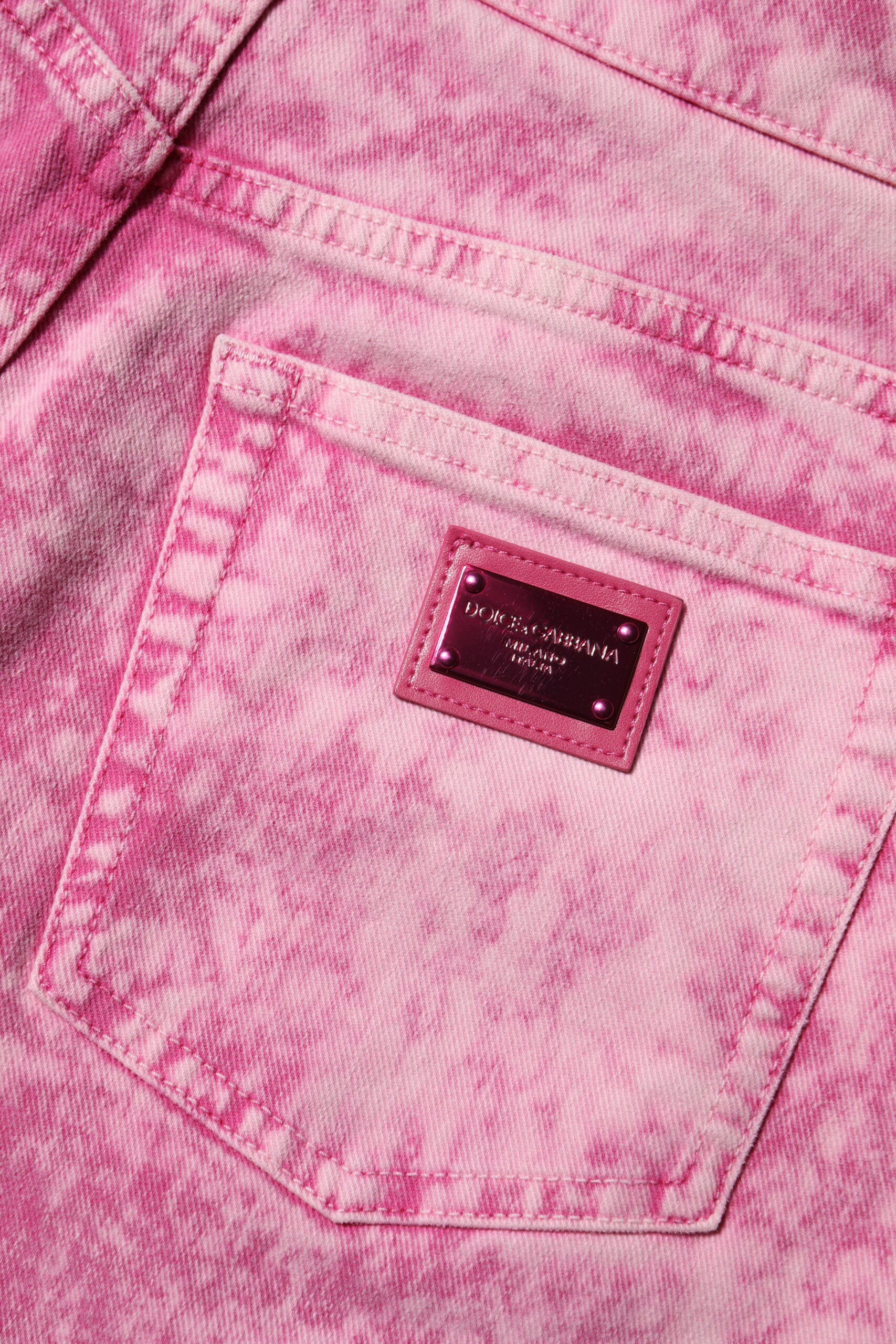 Jeans en denim rose tie-dye Dolce & Gabbana à taille haute et coupe tapered, mode tendance et élégante.