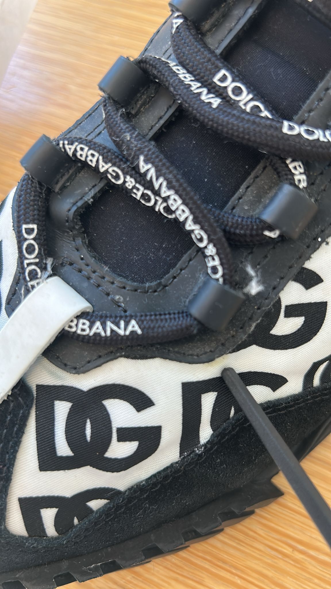 Chaussures basses Nike NS1 noires avec logo Dolce & Gabbana, lacets, design élégant et moderne visible en détail.