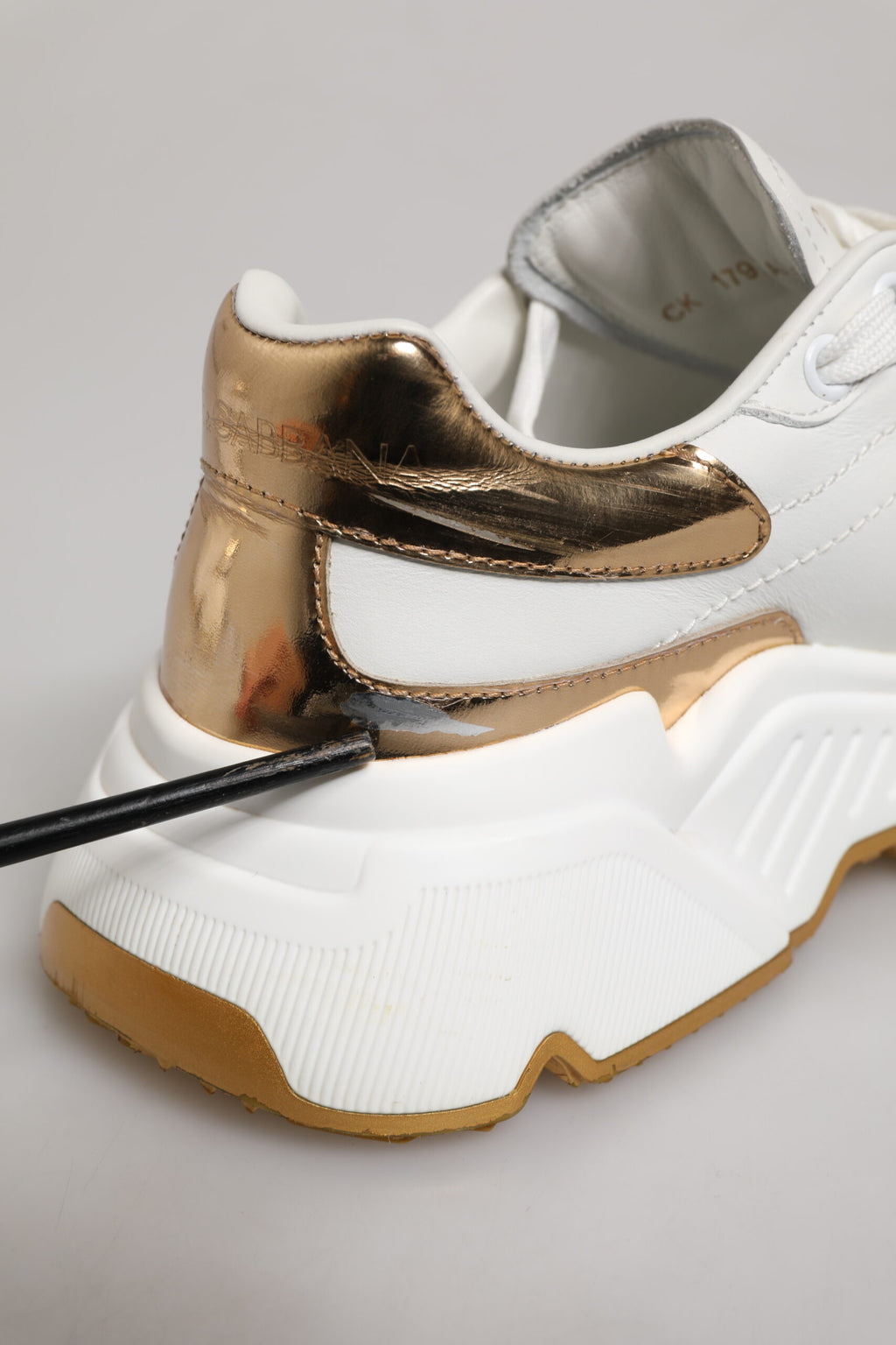 Chaussures sneakers en cuir blanc Dolce & Gabbana DAYMASTER avec détails en or, vue de face montrant le design élégant.