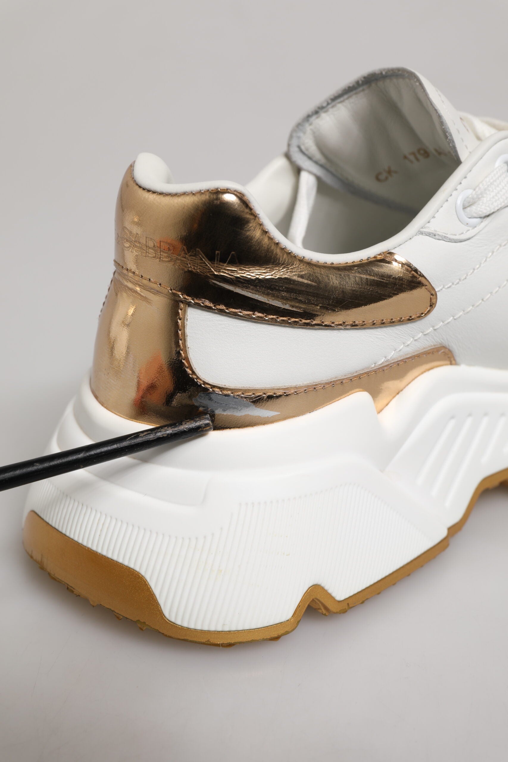 Chaussures sneakers en cuir blanc Dolce & Gabbana DAYMASTER avec détails en or, vue de face montrant le design élégant.