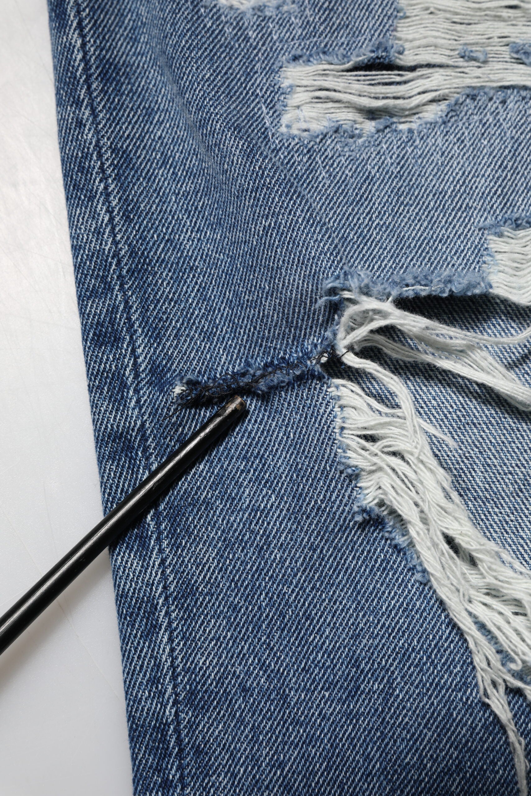 Jeans en denim bleu déchirés à taille haute pour femme de Dolce & Gabbana, style décontracté et tendance.