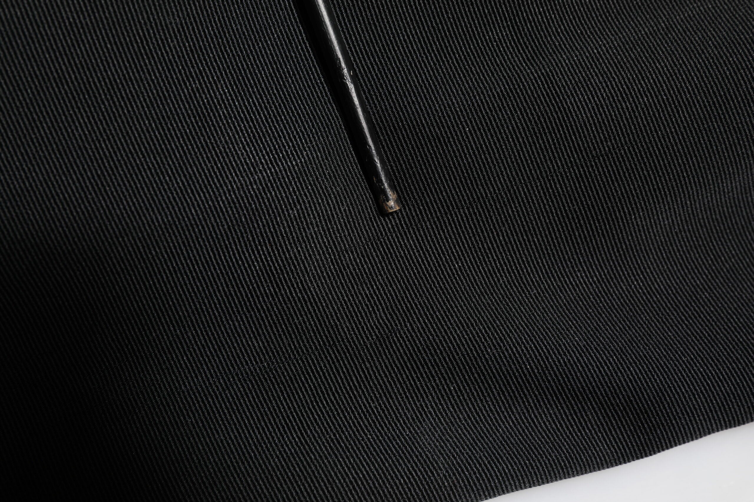 Pantalon noir Dolce & Gabbana en acétate à taille haute et coupe tapered, vue en détail sur le produit.