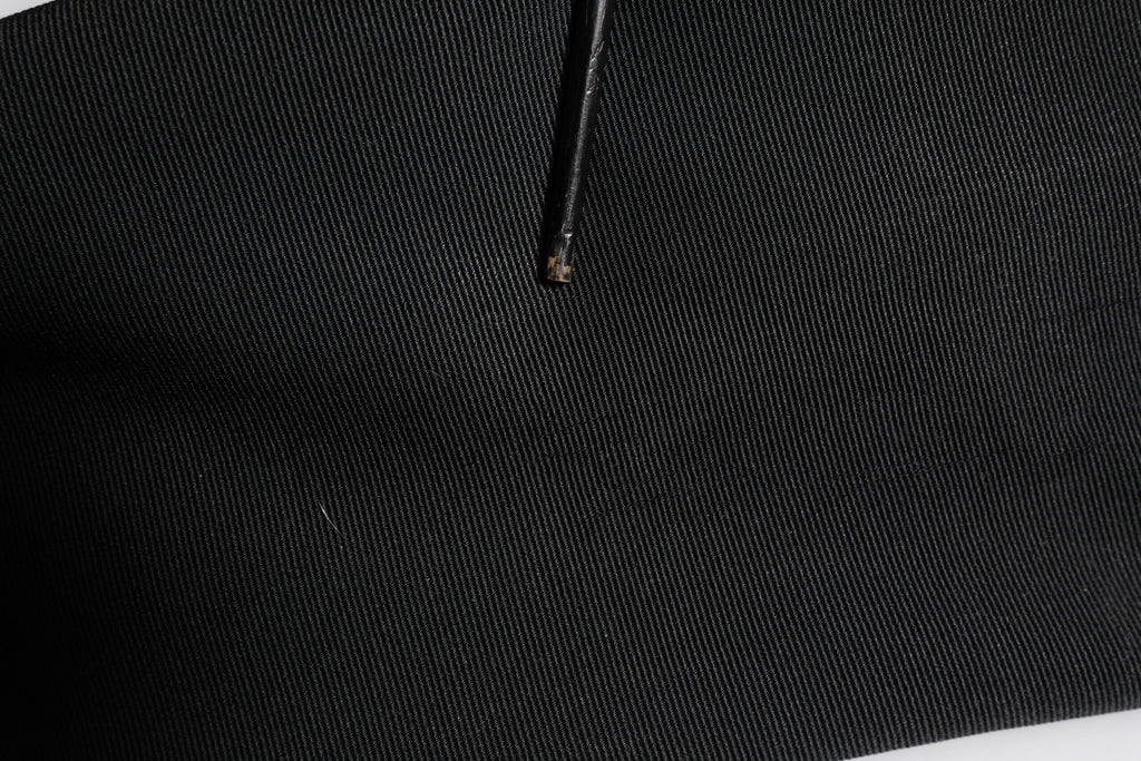 Pantalon noir en acétate à taille haute et coupe tapered par Dolce & Gabbana, vue de face.