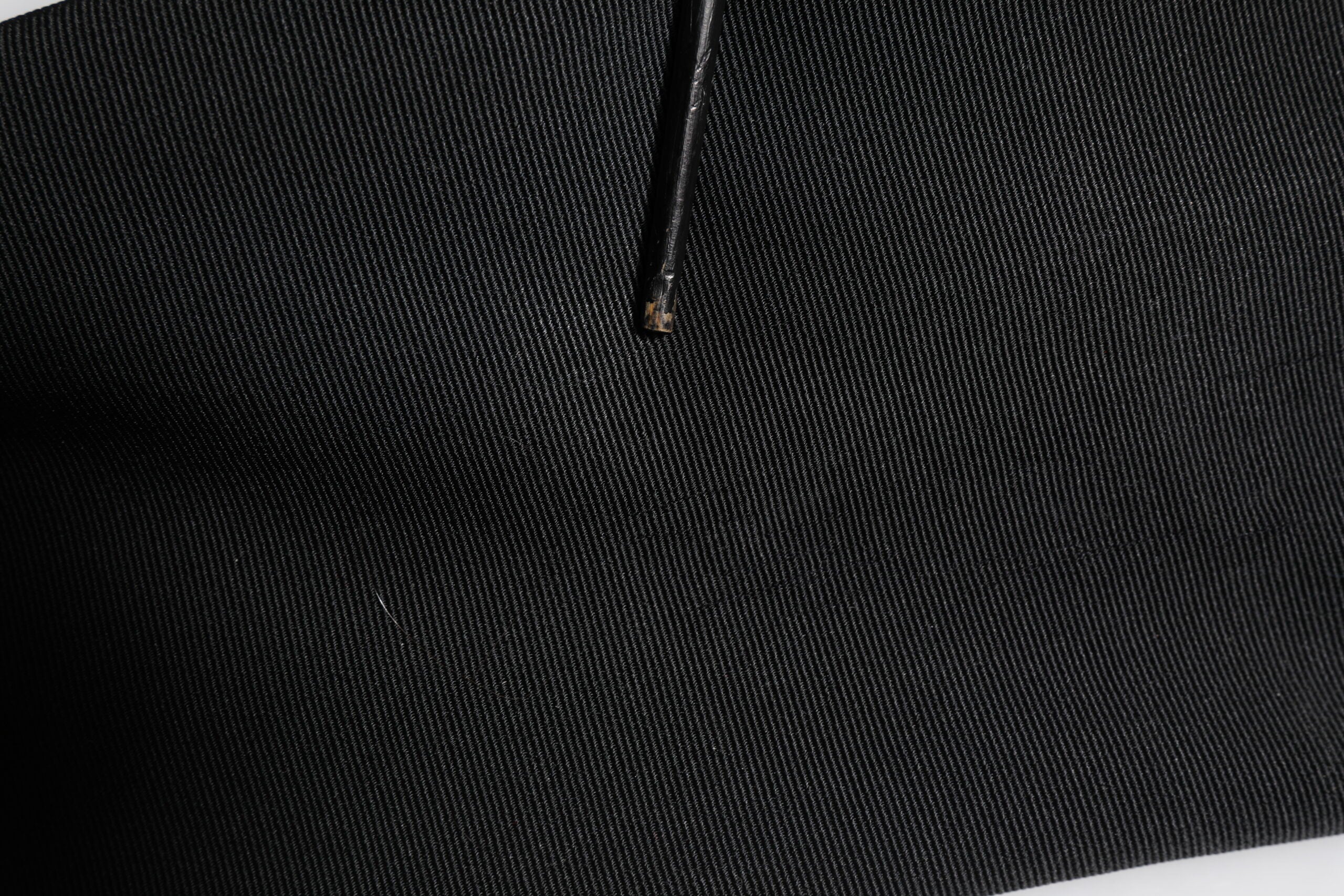 Pantalon noir en acétate à taille haute et coupe tapered par Dolce & Gabbana, vue de face.