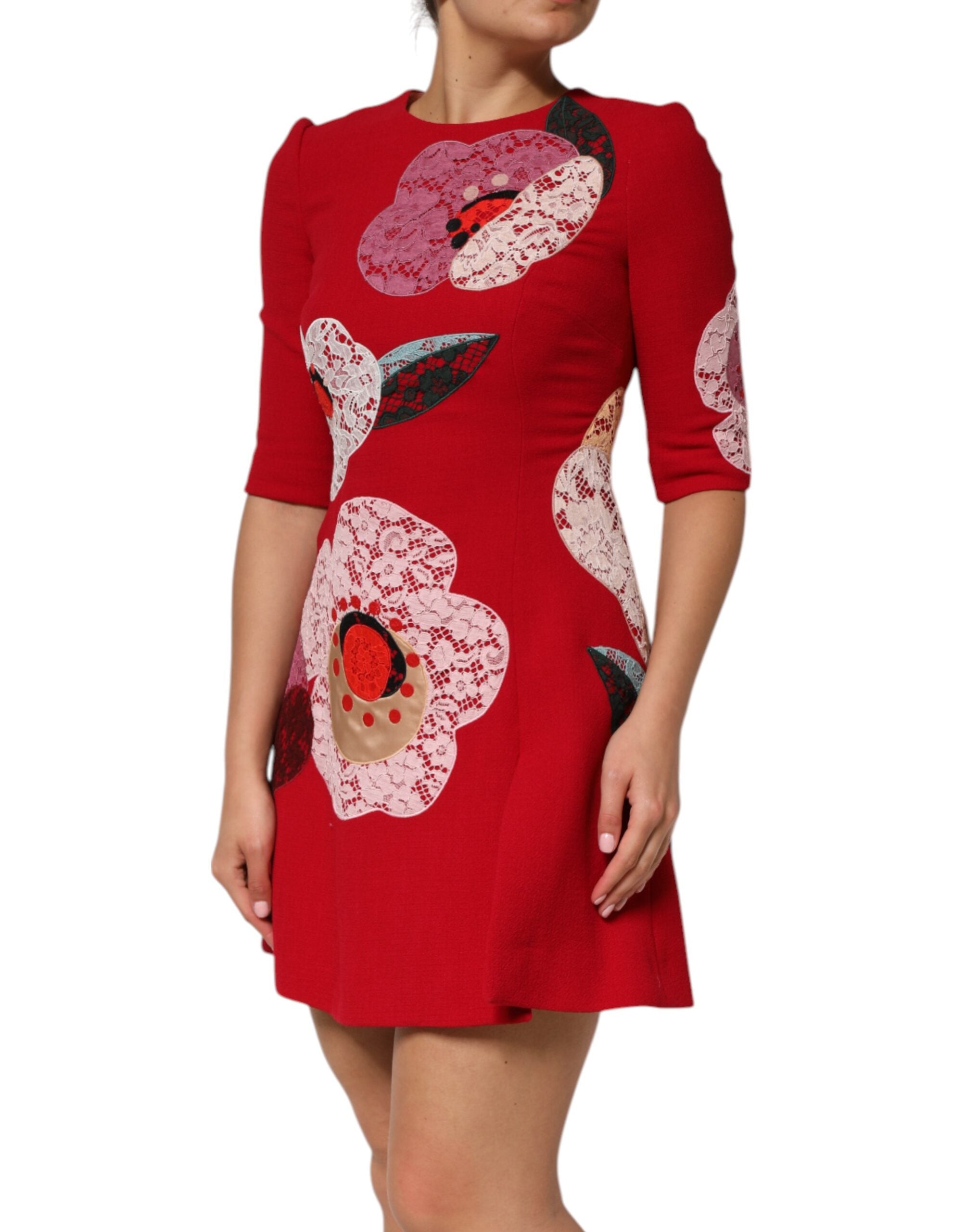 Robe courte en dentelle rouge Dolce & Gabbana avec appliqué floral et coupe en ligne A, portée élégante et féminine.