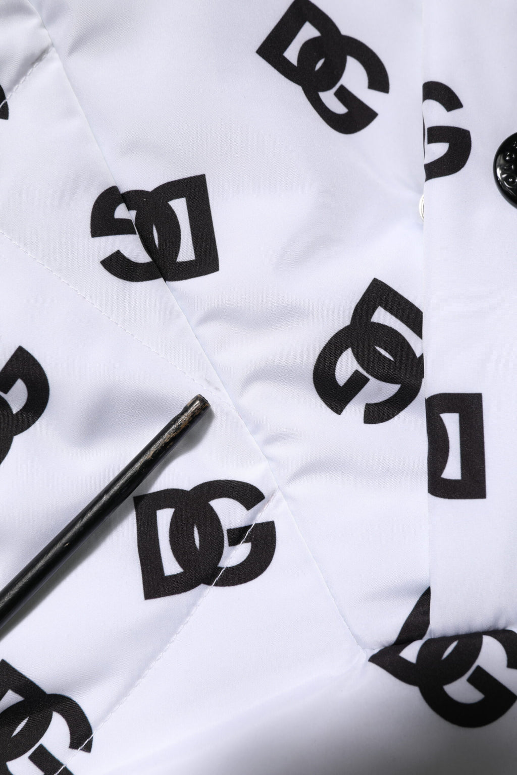 Veste matelassée blanche Dolce & Gabbana DG Monogram avec capuche, style élégant et moderne, visible en détail dans l'image.