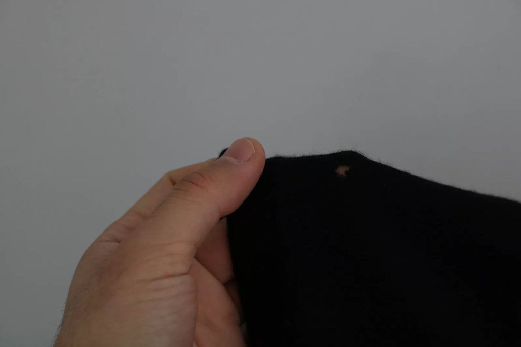 Pull en cachemire noir Dolce & Gabbana à col rond, doux et élégant, visible en détail dans l’image.